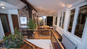 Un vaste espace de vie comprenant un escalier, une table à manger et une vue sur l’extérieur.