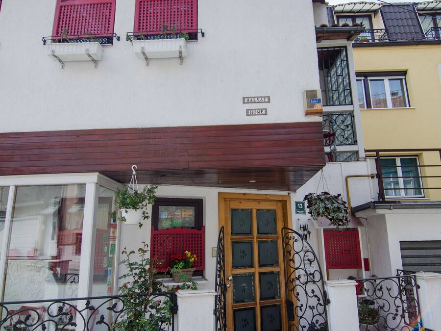 Un edificio de dos pisos con una puerta roja, un balcón con barandillas rojas y un letrero que dice "BAYVIEW HOME".