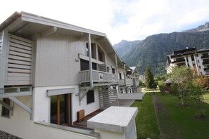 A multi-story hotel with balconies and a view of mountains. - Hotel Les Lanchers (Chamonix-Mont-Blanc)