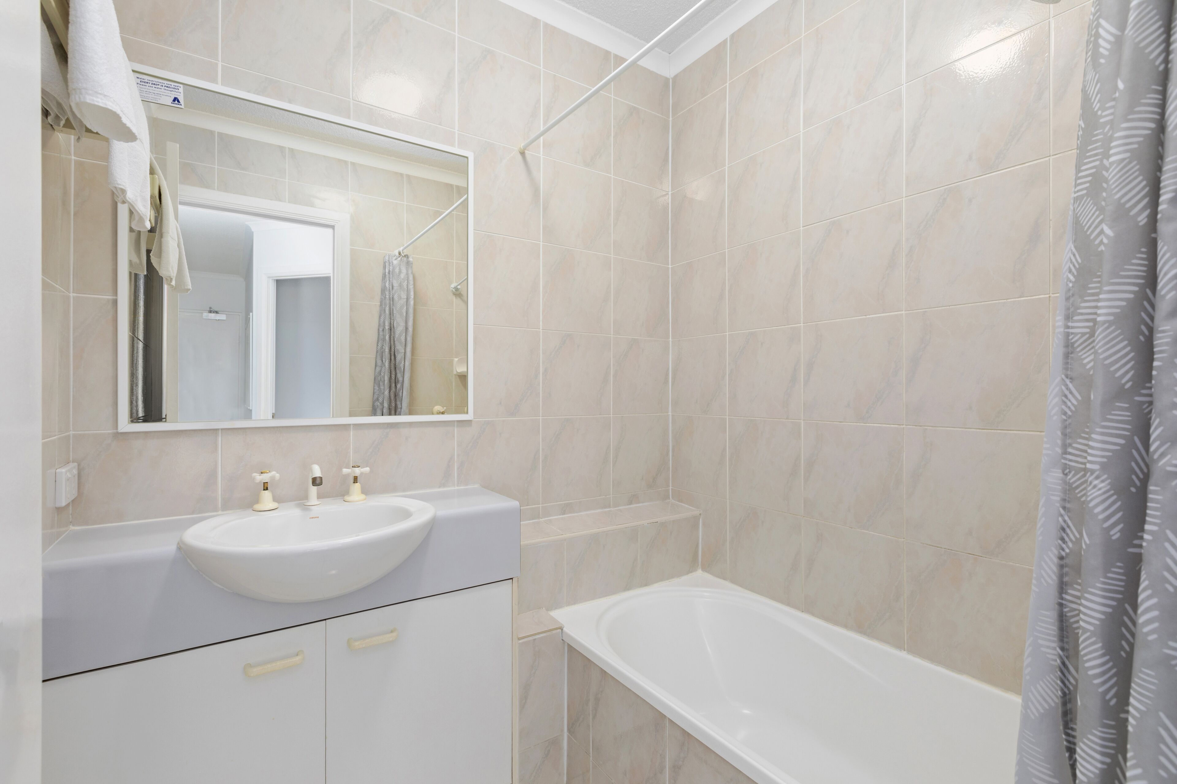 Ein Badezimmer mit Waschbecken, Spiegel und Badewanne.