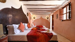 A hotel room with two beds, a red blanket, and a decorative wall. - Riad Sidi Mimoune (Marrakech)