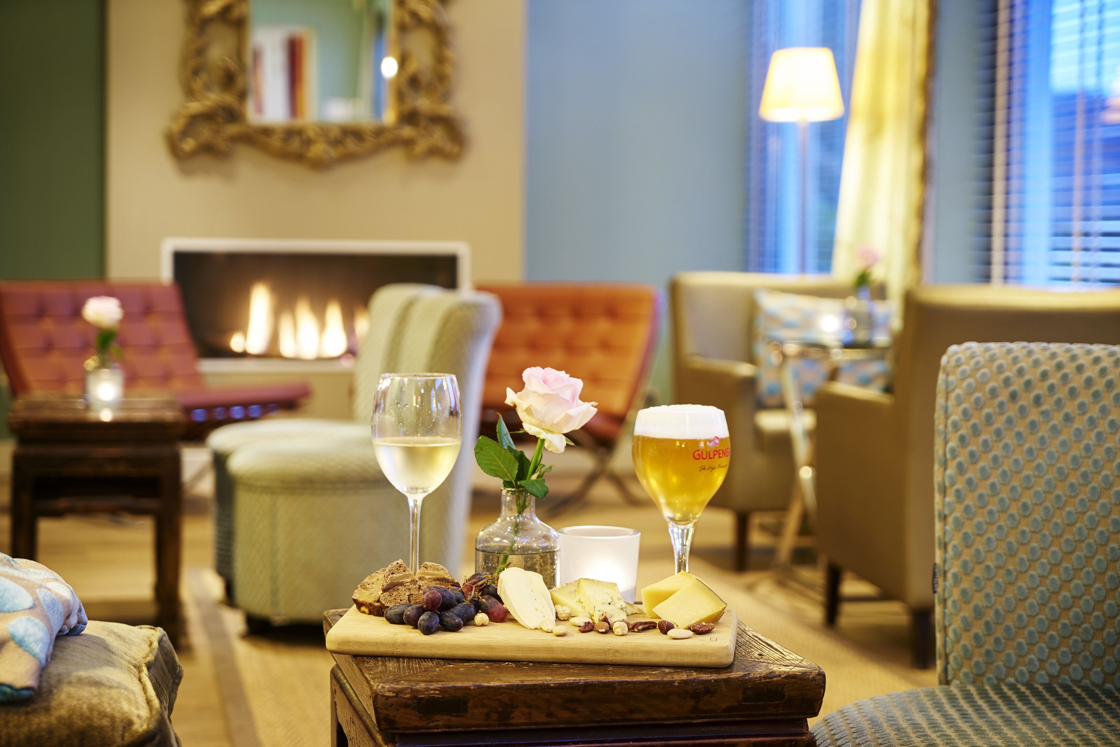 A cozy living room with a fireplace, comfortable seating, and a table with snacks and drinks.