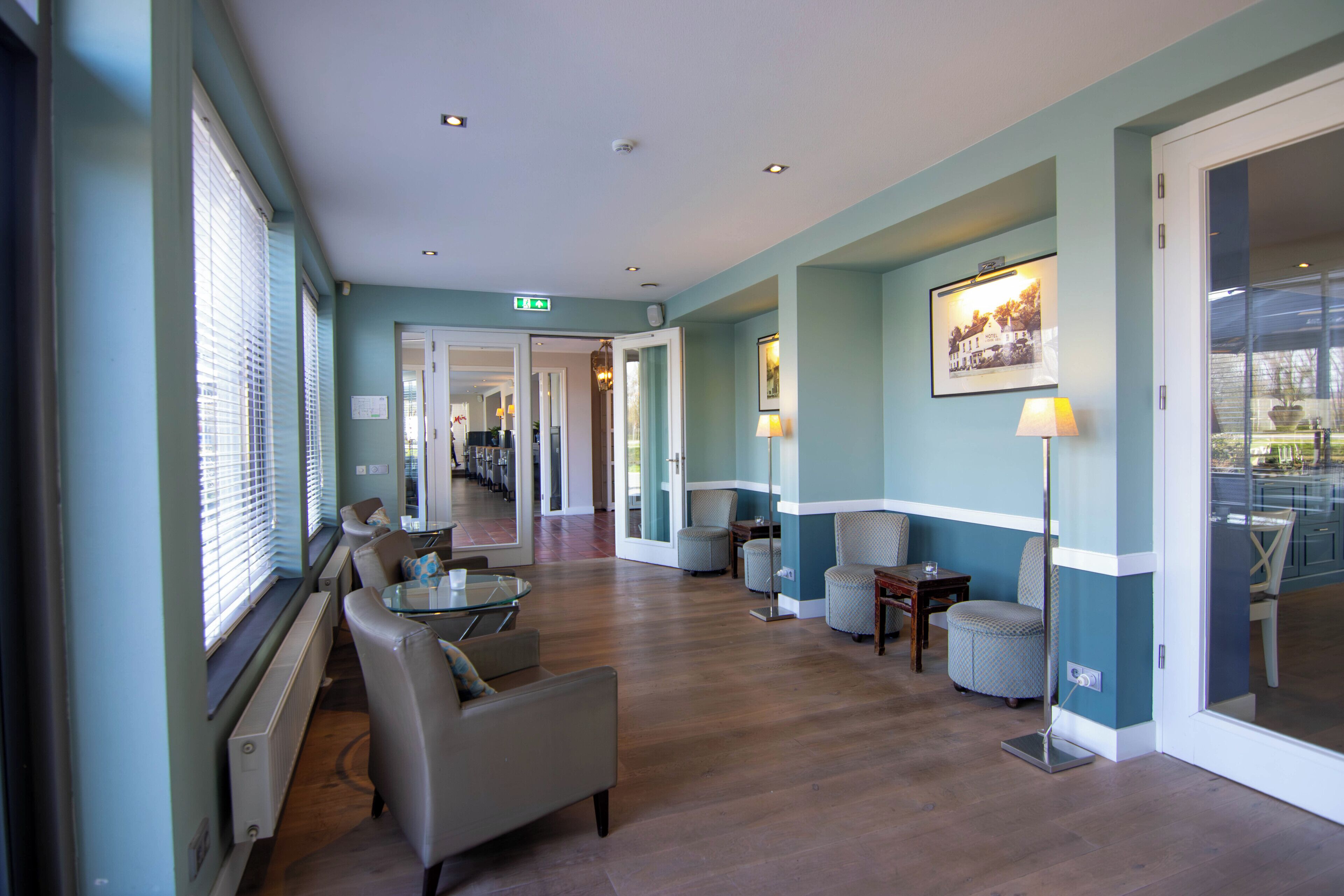 Un hall d’hôtel comprenant un comptoir d’accueil, un espace salon et un couloir menant aux autres chambres.