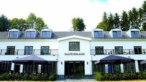 A hotel with a white facade, multiple windows, and a sign reading "GULPENERLAND". - Hotel Gulpenerland  (Gulpen)