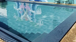 A swimming pool with a mural of flamingos and waves on the adjacent wall. - Cascades Motor Inn  (Dubbo)