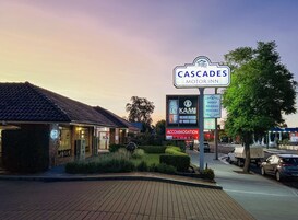 A motel sign with "Cascades Motor Inn" and a "Kami Japanese Restaurant" sign nearby.