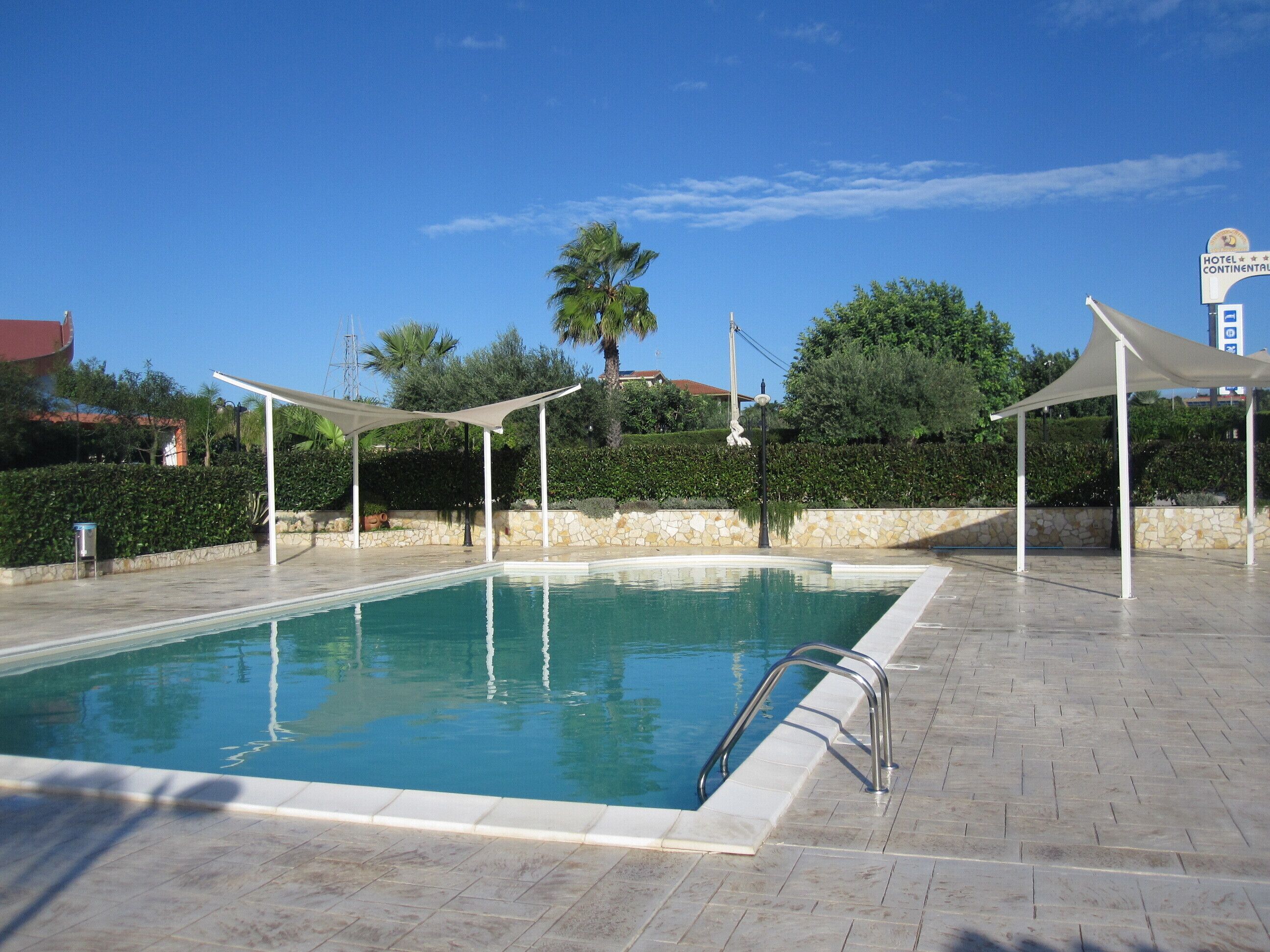 En säsongsöppen utomhuspool och solstolar