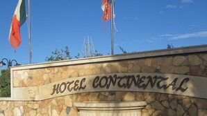 Un muro de piedra con el texto "HOTEL CONTINENTAL" y una escultura decorativa de caballito de mar.