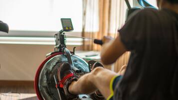 A stationary bike with a digital display and a user pedaling.