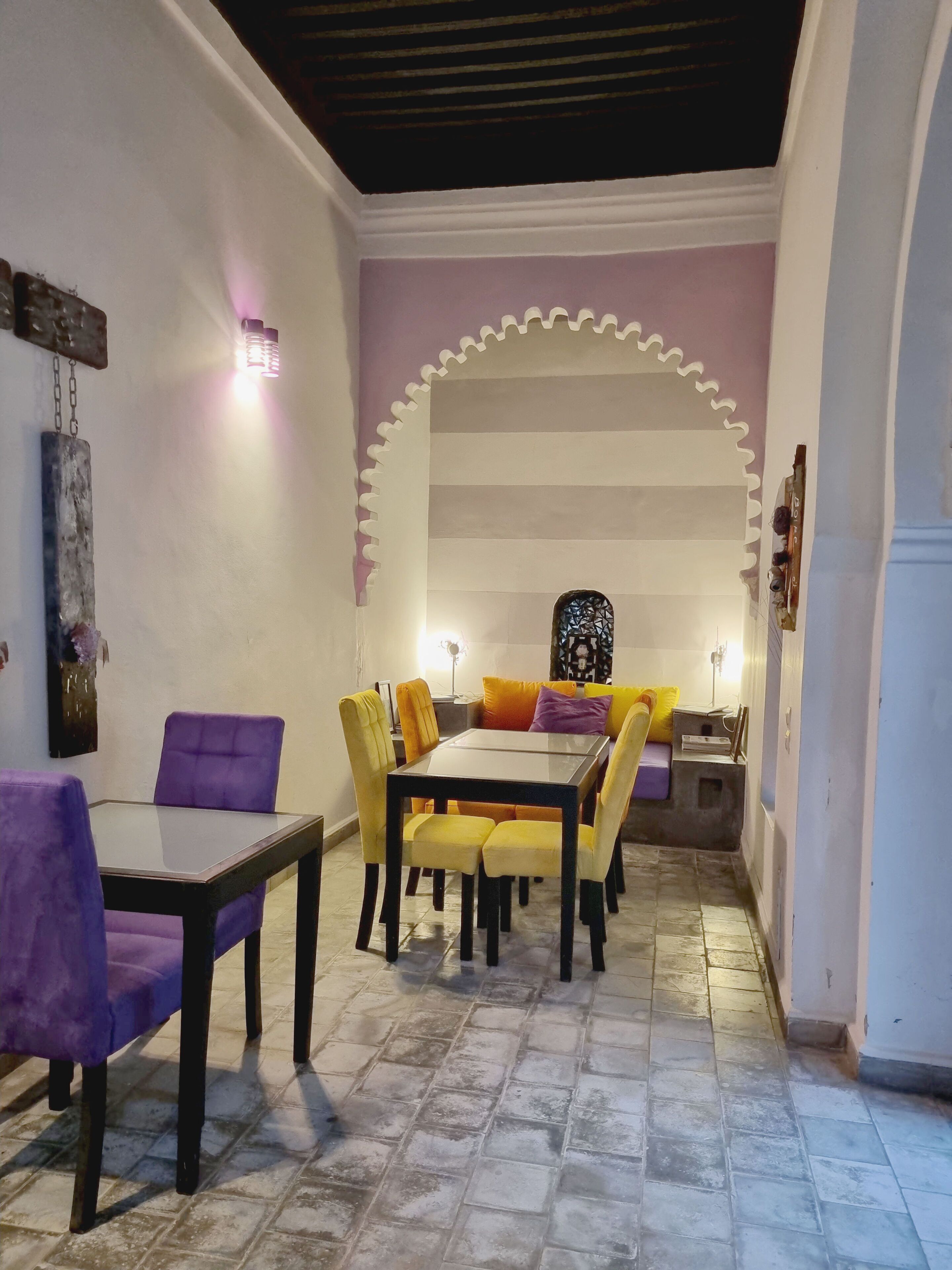 A dining area with a table and chairs, a decorative wall, and a patterned ceiling.