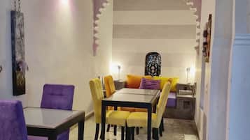A dining area with a table and chairs, a decorative wall, and a patterned ceiling.
