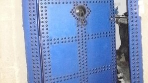 A blue door with a circular emblem and a sign that reads "RIAD7".