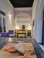 Un comedor con una mesa, sillas, un arco decorativo y un cartel en la pared.