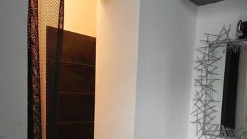 Un baño moderno con un lavabo blanco, encimera negra y un espejo decorativo.