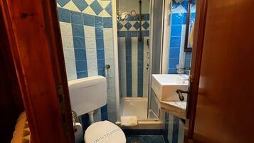Un baño con inodoro, ducha y lavamanos.