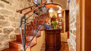A wooden staircase with a wrought iron railing leading to a reception desk. - Hotel Monte Cristo (Kotor)