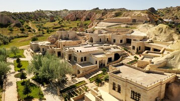Un complesso di edifici in pietra dalle linee classiche, con diverse strutture collegate, un cortile centrale e vegetazione circostante.