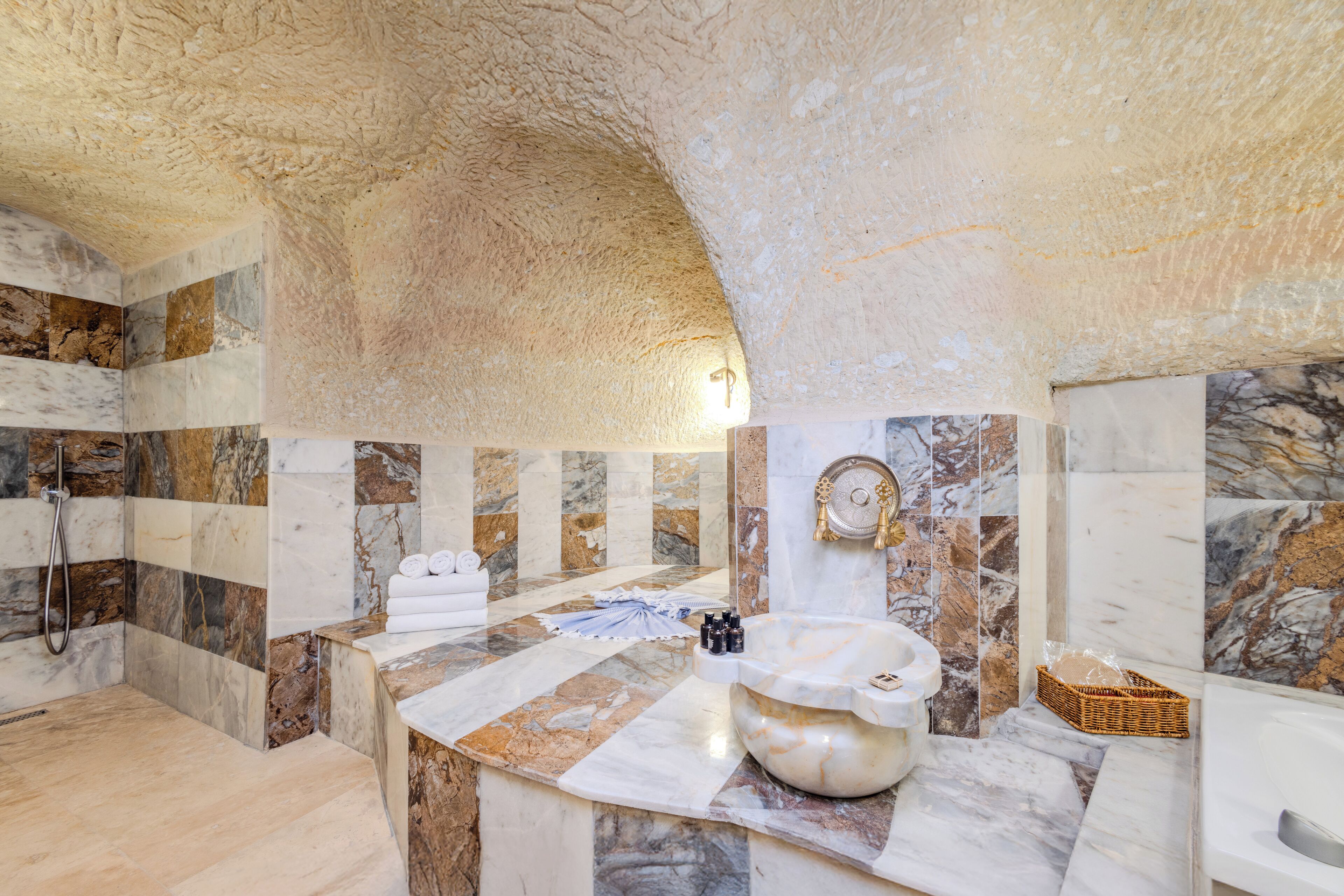 Ein luxuriöses Badezimmer mit Marmorwänden und einem großzügigen Waschbecken.