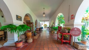 A corridor with arches, potted plants, and a sign indicating a private entrance.