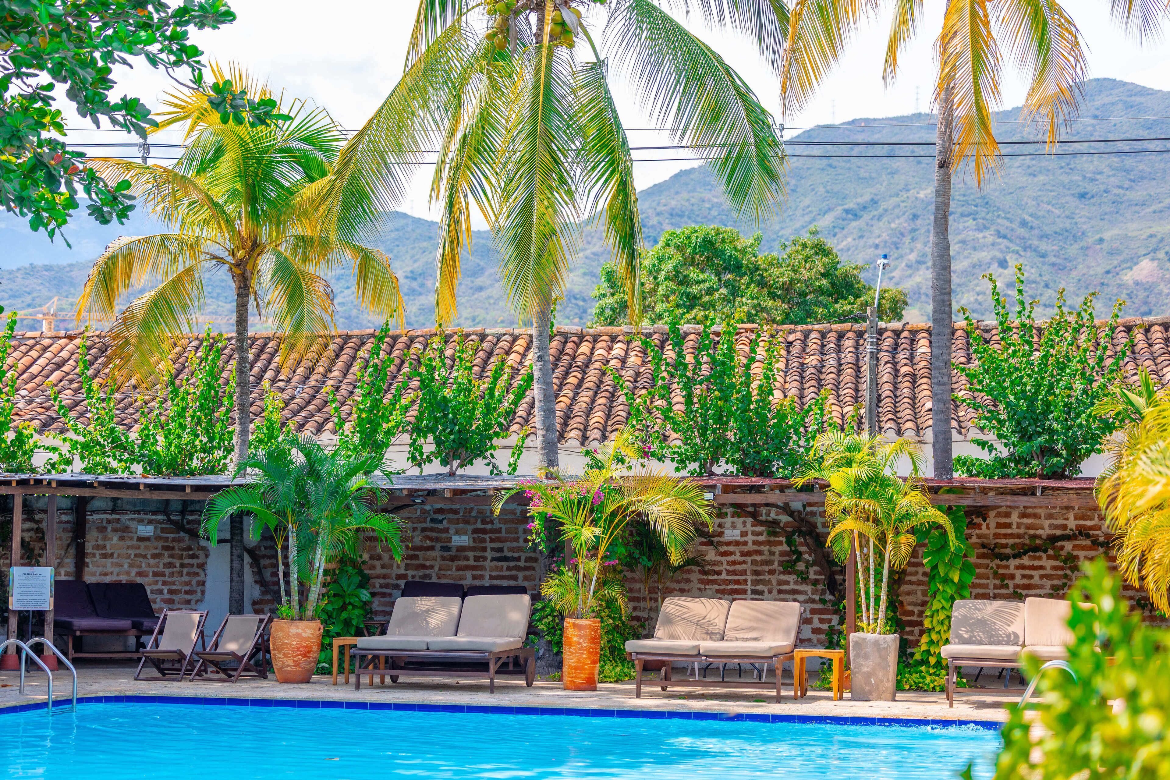 Una piscina al aire libre, sillones reclinables de piscina