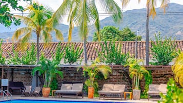 Una piscina al aire libre, sillones reclinables de piscina