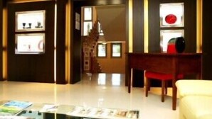 A hotel lobby with a reception desk, a seating area, and framed artwork on the walls. - Residence Diamanterosso (Terni)