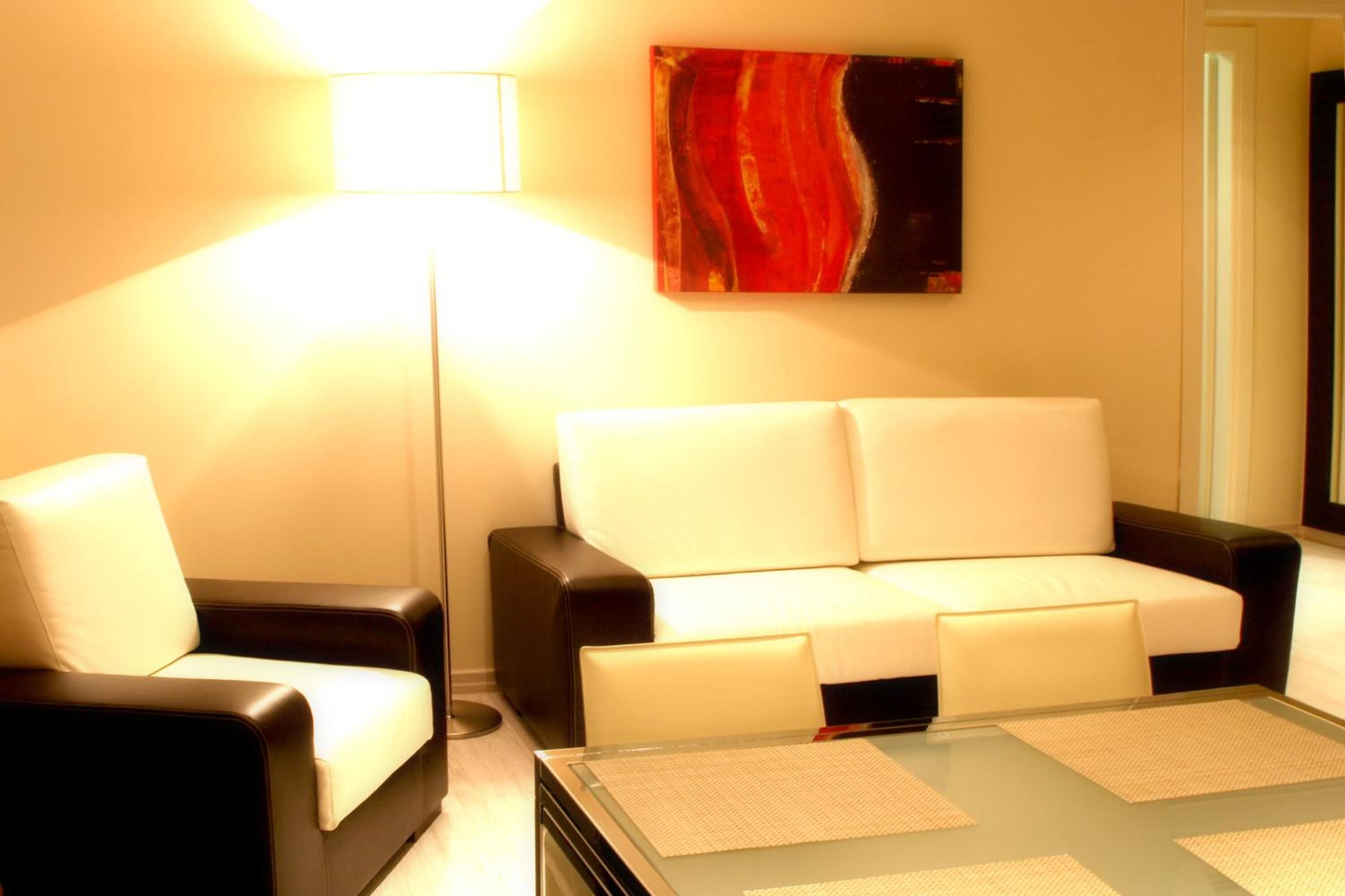 Ein modernes Wohnzimmer mit einer Couch, Sesseln und einem Couchtisch.