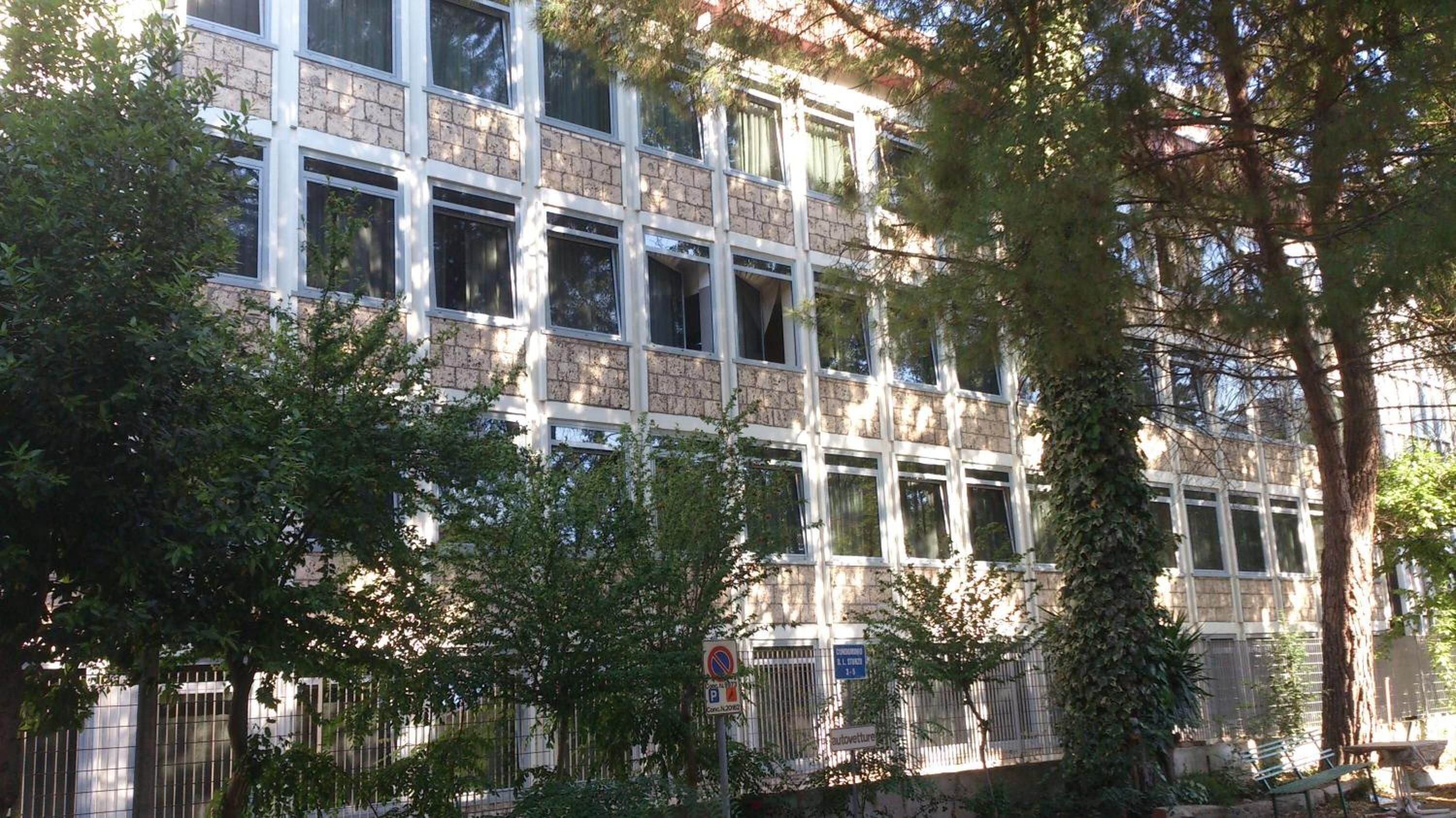 A multi-story building with large windows and a brick facade.