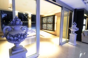 Un intérieur moderne agrémenté d’un grand vase décoratif et d’une œuvre d’art encadrée au mur.