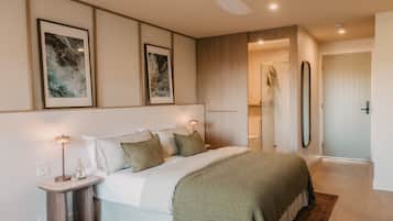 A bedroom with a bed, bedside tables, a ceiling fan, and artwork on the wall.