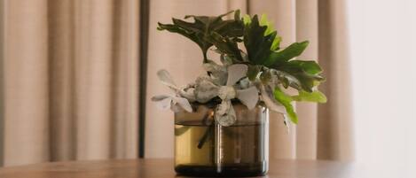 A round table with a vase of plants and a chair.