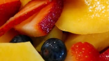 A close-up of a fruit salad with strawberries, blueberries, and pineapple.