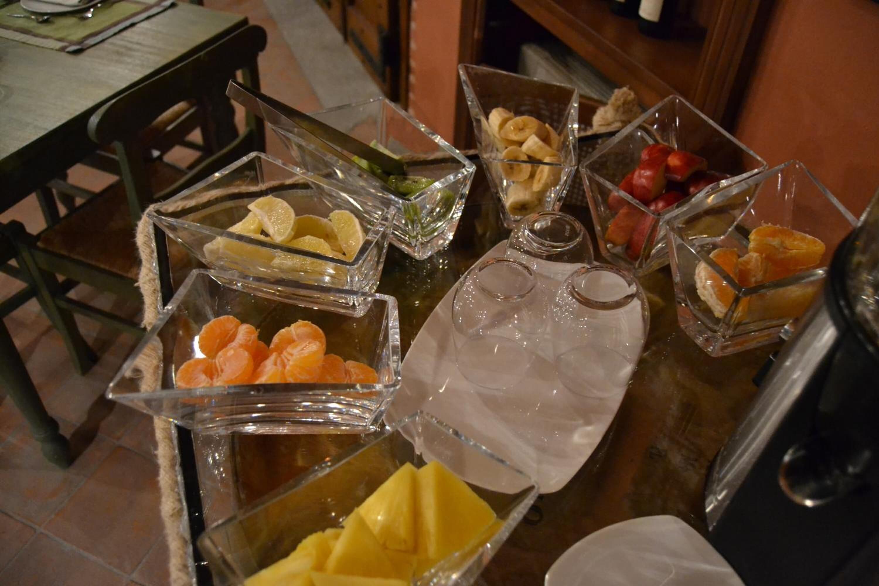 Una mesa de buffet con diversos alimentos y una jarrón de agua.