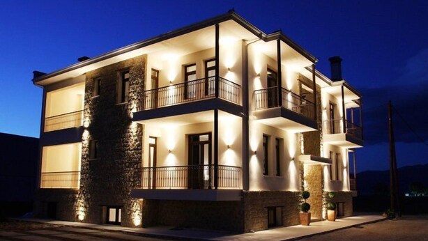 Un edificio de varios pisos con balcones e iluminación exterior.