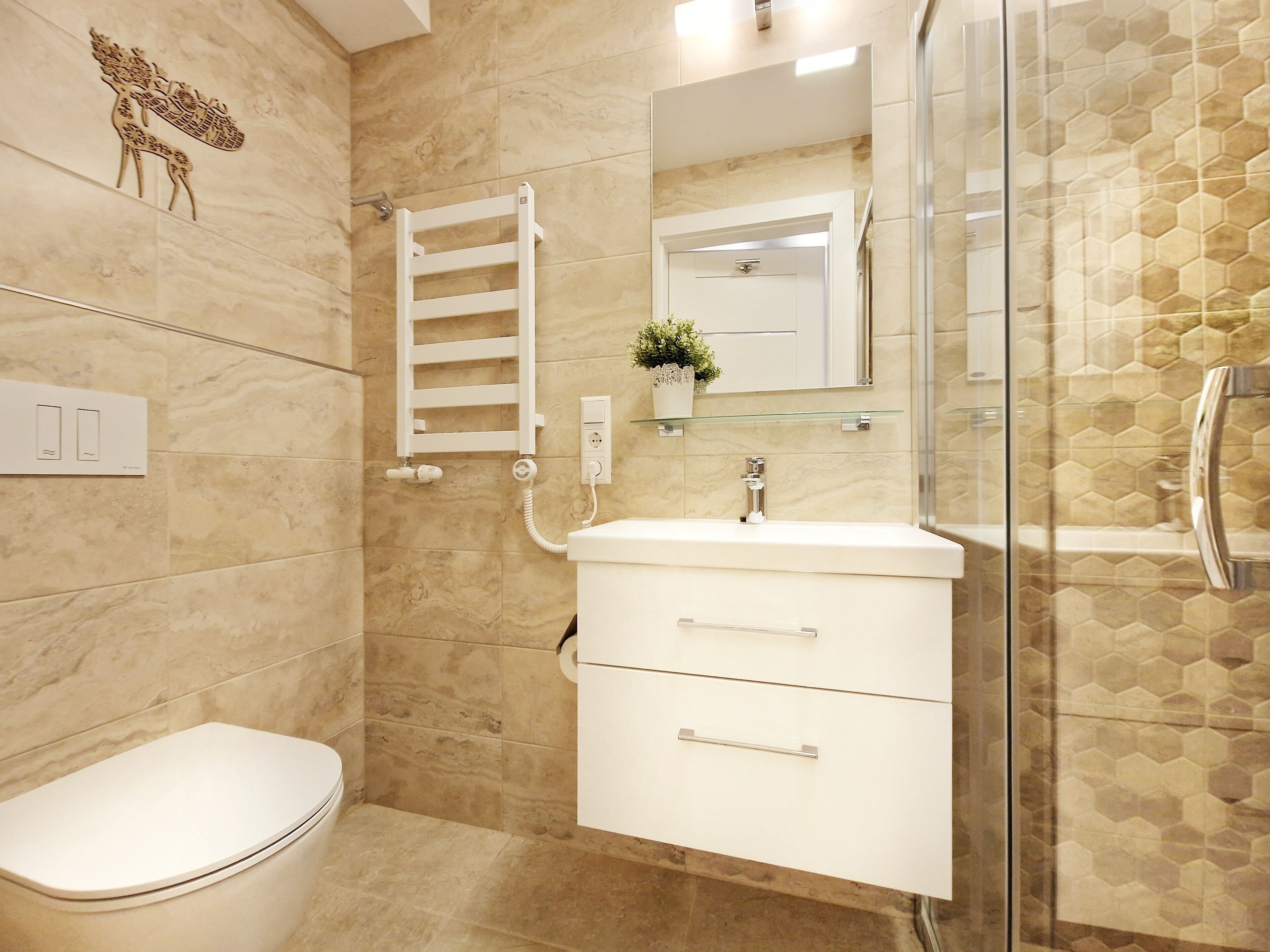 Un baño con inodoro, lavamanos con espejo y zona de ducha.