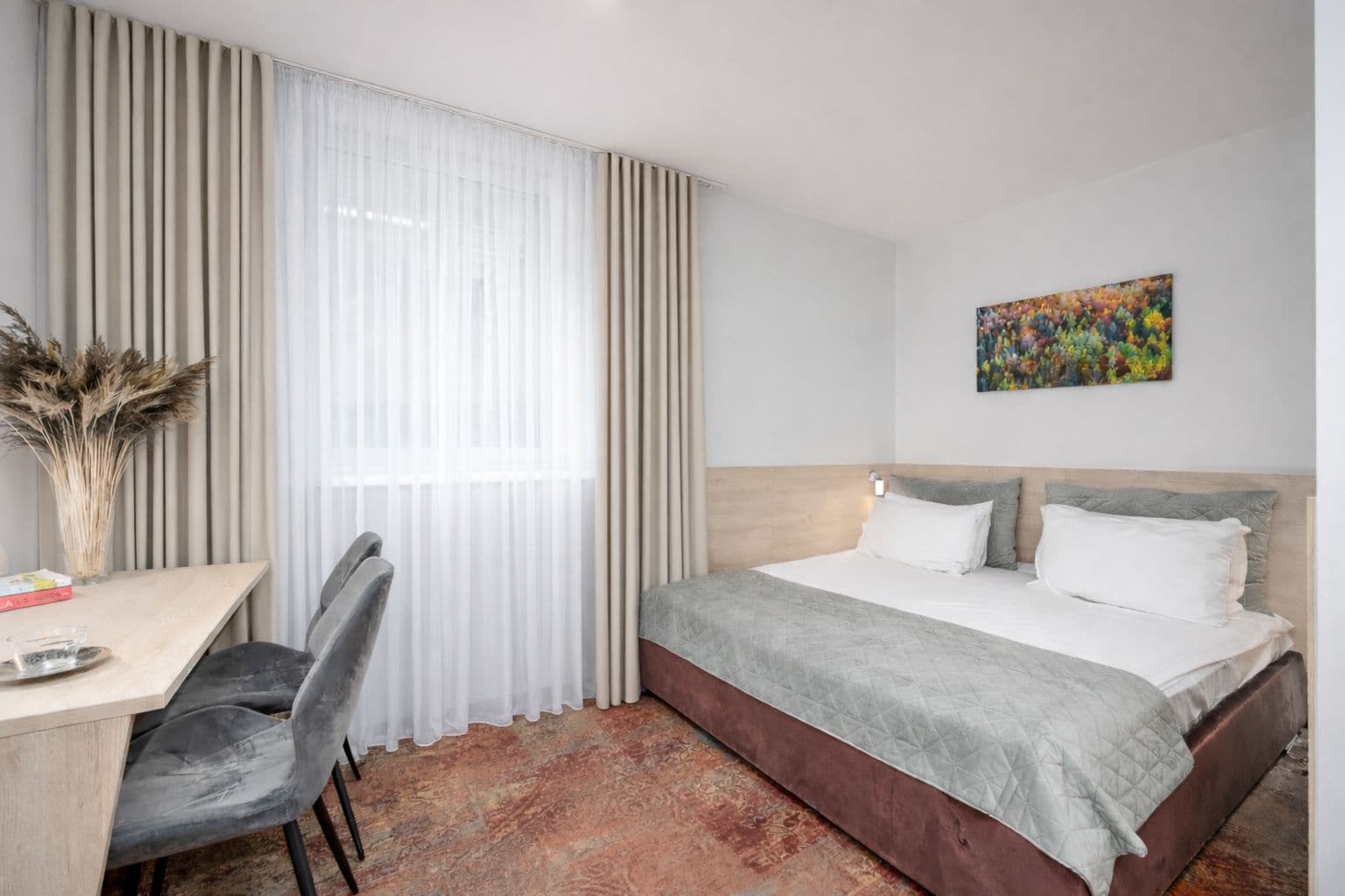 Una habitación de hotel con una cama, un escritorio y una silla.