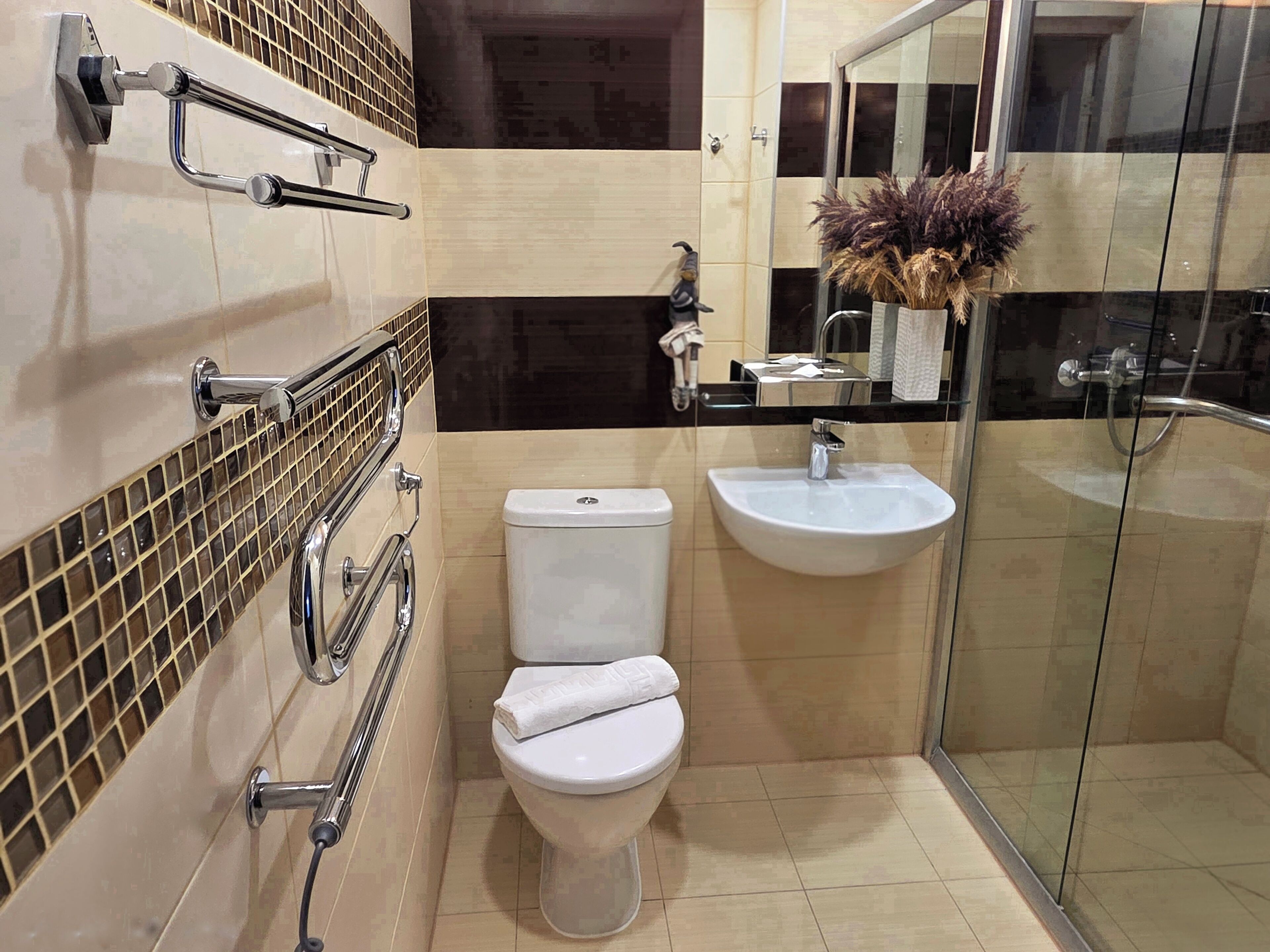 A modern bathroom with a toilet, sink, and glass shower enclosure.