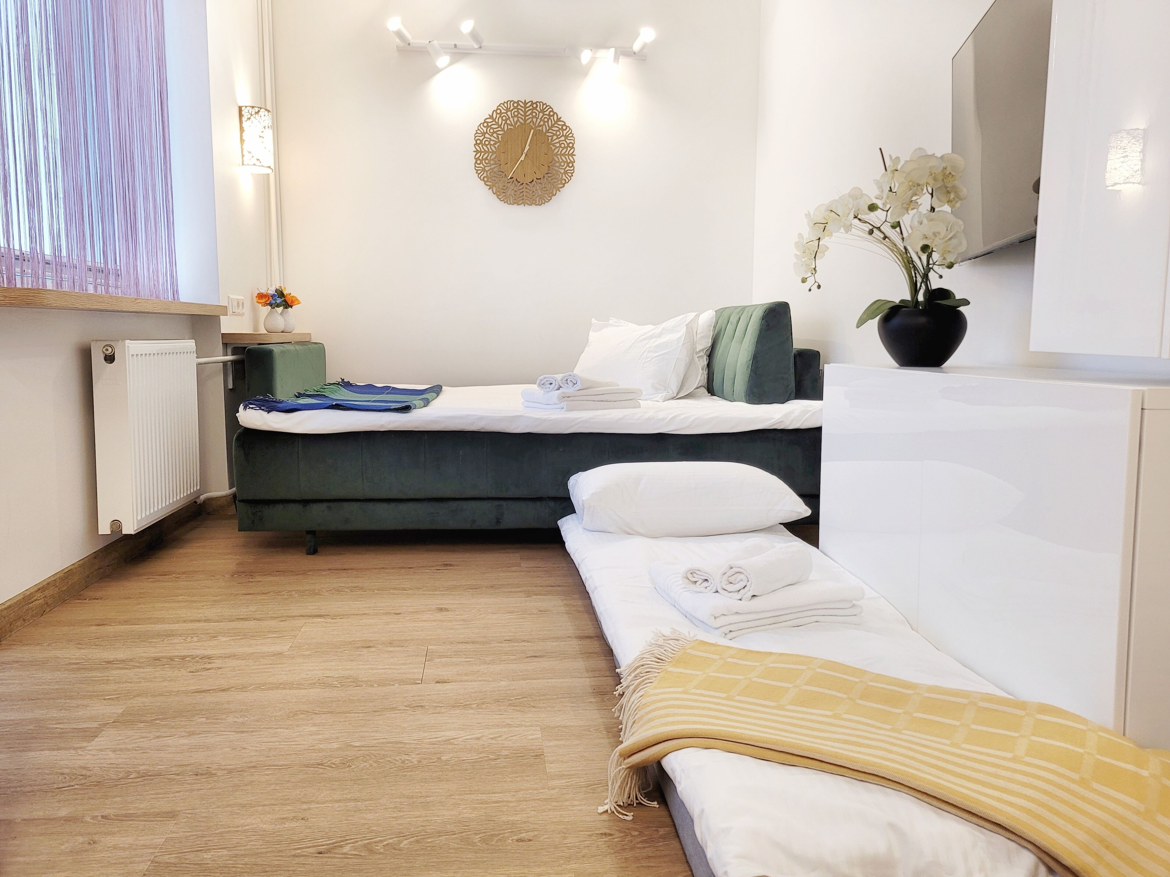 Une chambre à coucher moderne avec un lit, une table de chevet et une plante en pot.