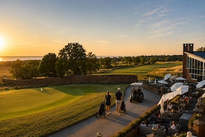 Un campo de golf con un club de campo y zona de estar al aire libre.