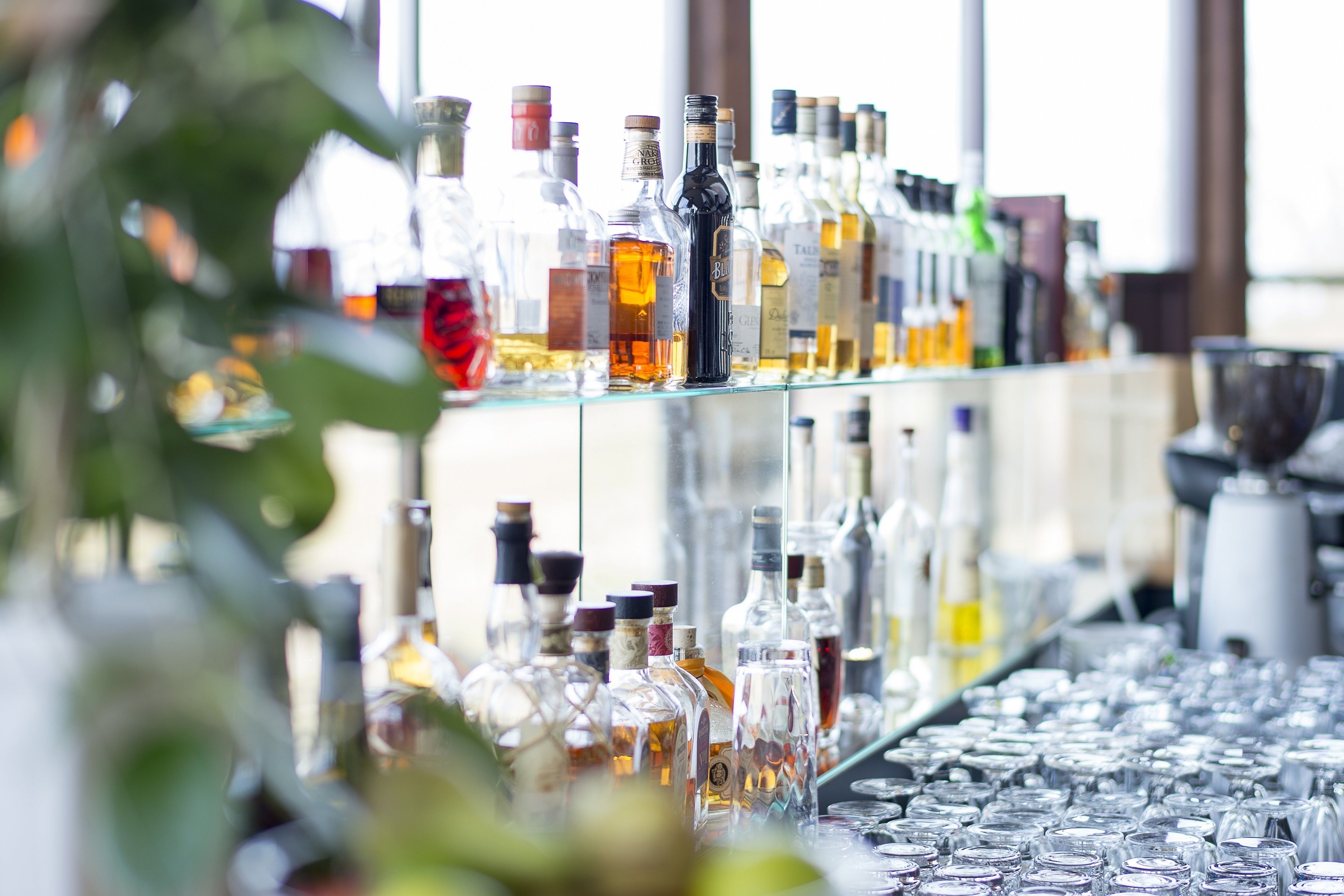 Een bar met verschillende flessen en glazen.