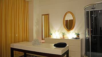 Enjoy a restful stay in this inviting room featuring a comfortable bed, a spacious mirror, and a modern glass-enclosed shower.