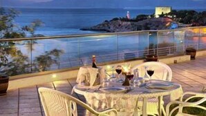 A table set for two with a bottle of wine and glasses, overlooking a coastal view with a lighthouse in the distance. - LaVista Boutique Hotel & Spa - Boutique Class (Kusadasi)