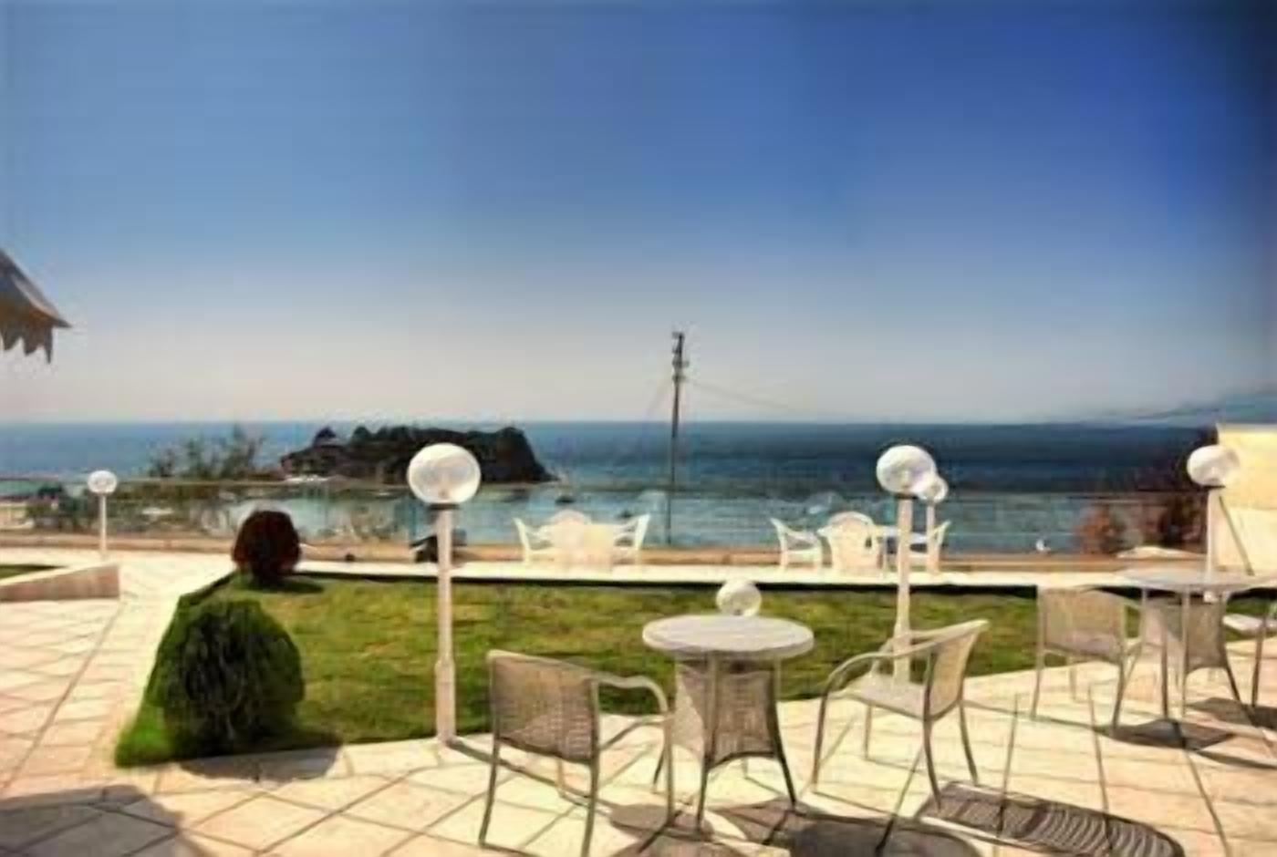 Una terrazza con posti a sedere all'aperto e vista sul mare.