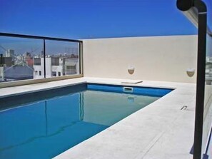 Alberca al aire libre y camastros 