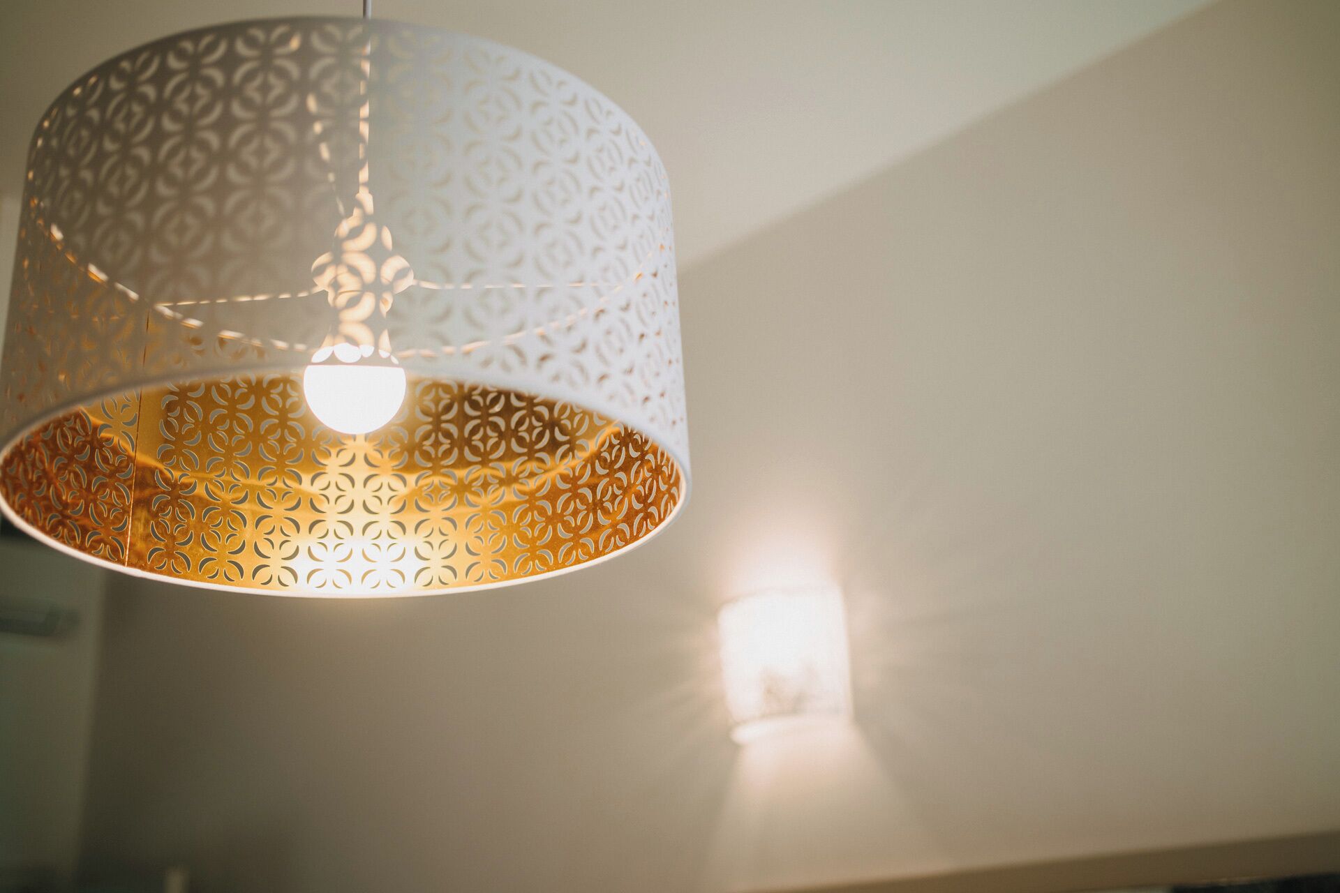 A hanging light fixture with a patterned design.