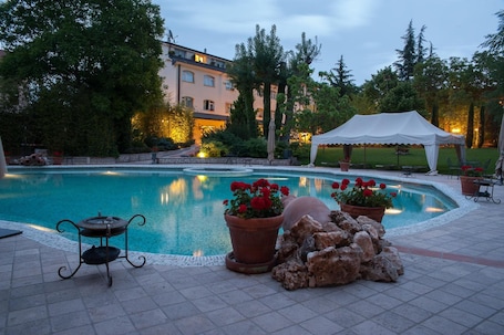 Una piscina al aire libre, sillones reclinables de piscina