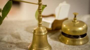 A brass bell and a brass bell with a dome on a stone surface.