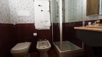 Ein Badezimmer mit Toilette, Bidet und einer Duschkabine.