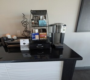 A coffee station with a Keurig coffee maker, a coffee pod holder, and a coffee cup. - Motel RDL au vieux piloteux (Rivière-du-Loup)