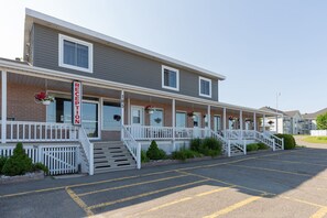 A two-story building with a reception area, numbered rooms, and a parking lot. - Motel RDL au vieux piloteux (Rivière-du-Loup)